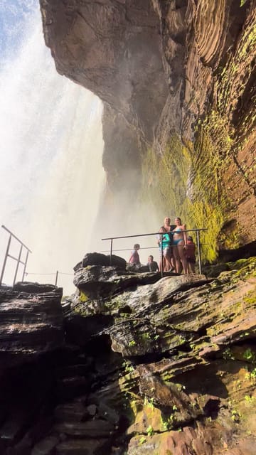 A queda do São Romão vista por trás da cortina d’água, com gente na laje junto ao corrimão