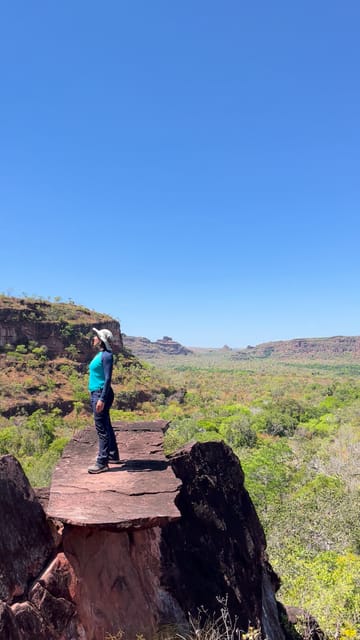 O cerrado e as mesas ao fundo, até uma pessoa de pé sobre uma pedra em forma de cogumelo